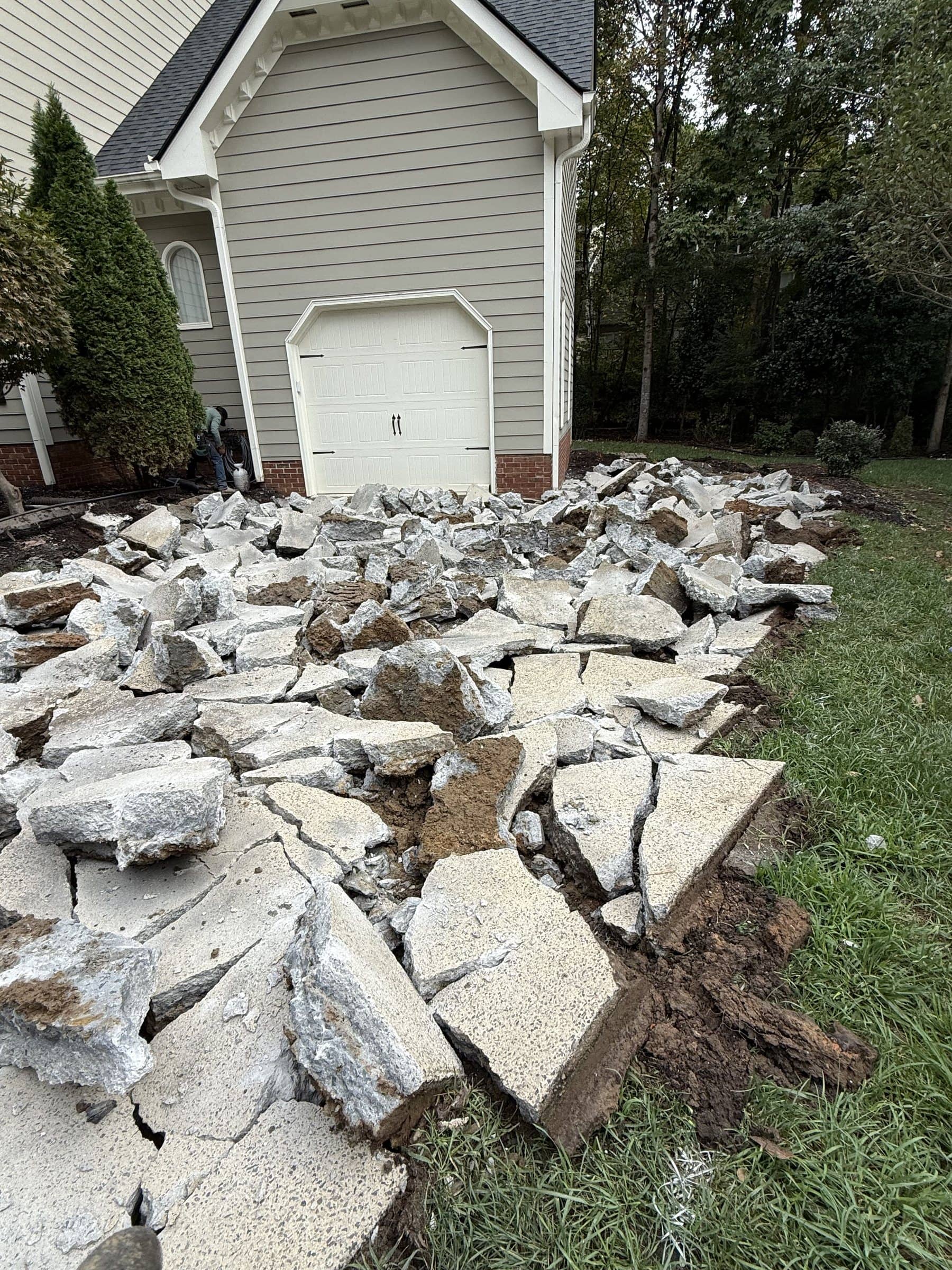 Old driveway broken out and ready for haul-away before a replacement pour in Cary, NC