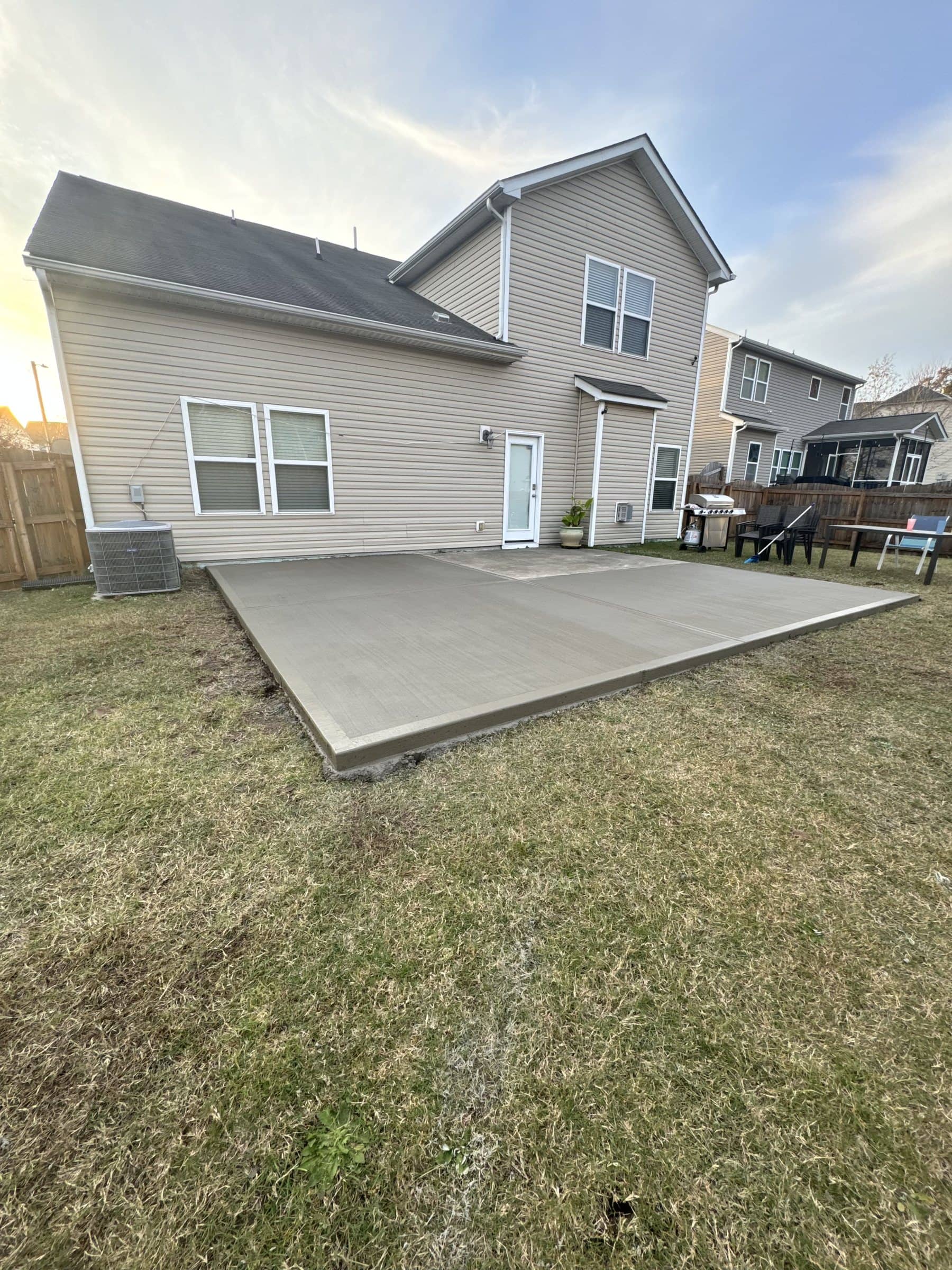 Back patio slab behind a two-story home