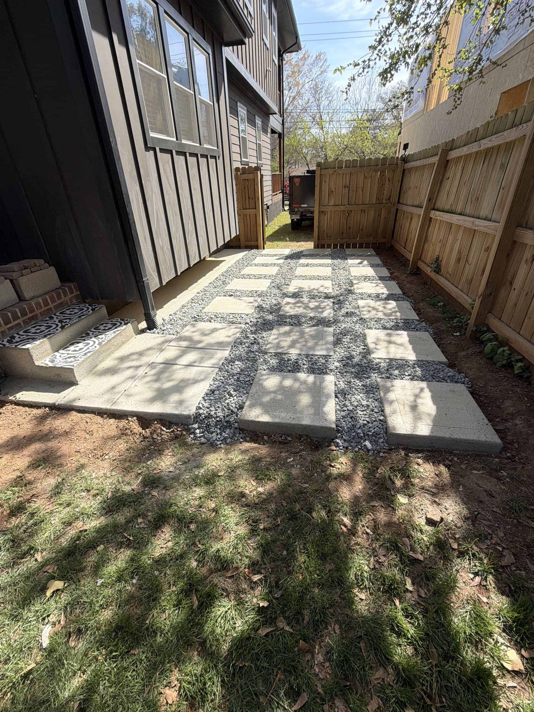 Side-yard patio of poured concrete pads with gravel joints