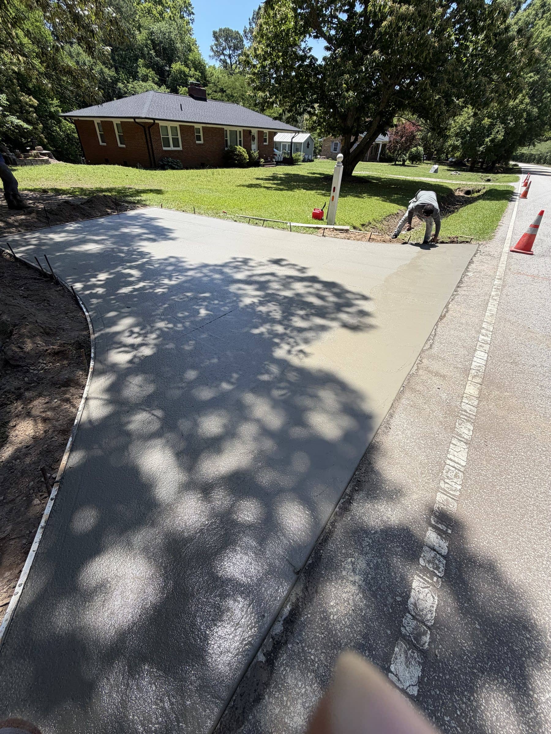 Crew member finishing a fresh concrete pour