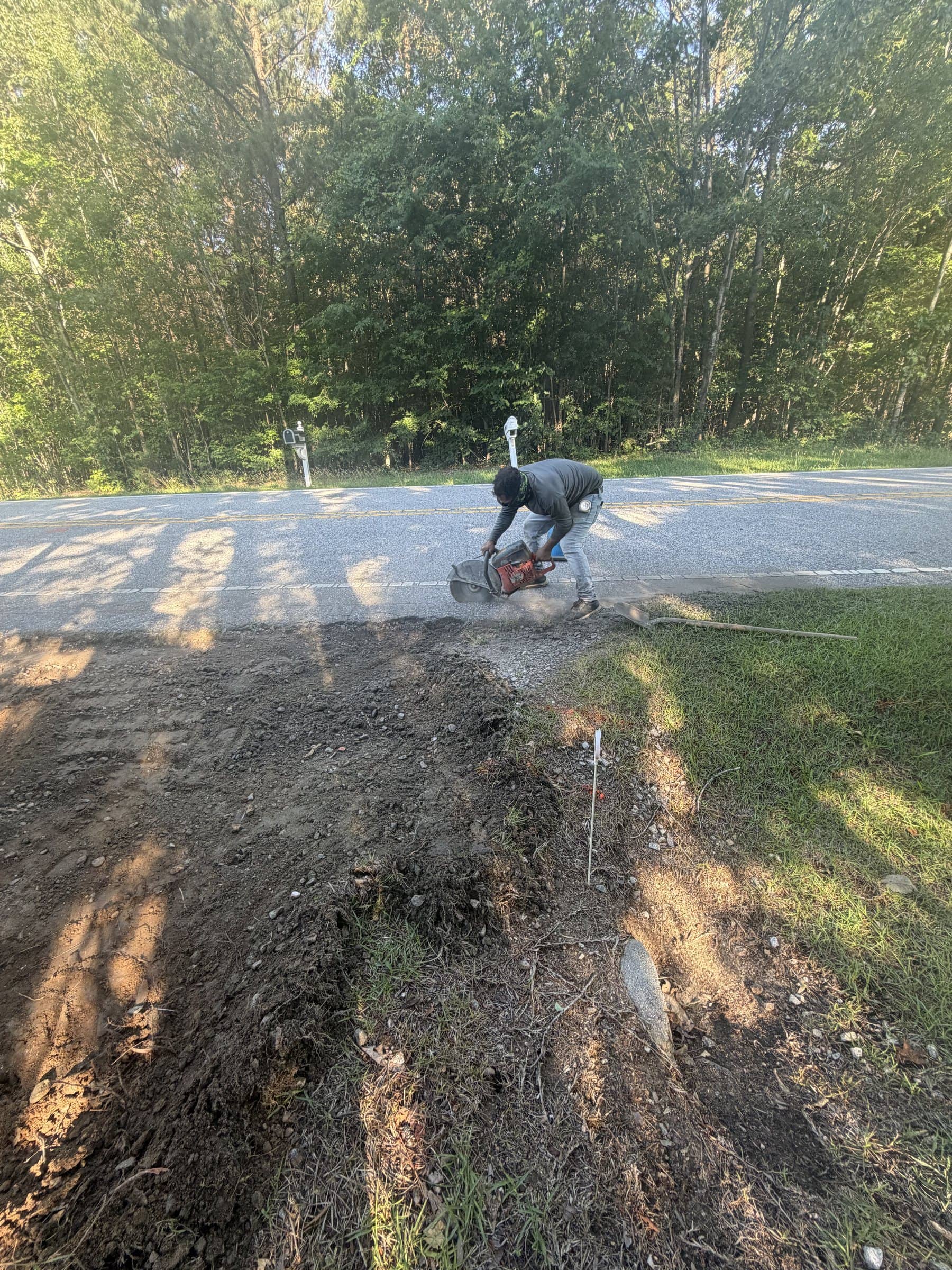 Saw-cutting the road edge before a driveway apron pour