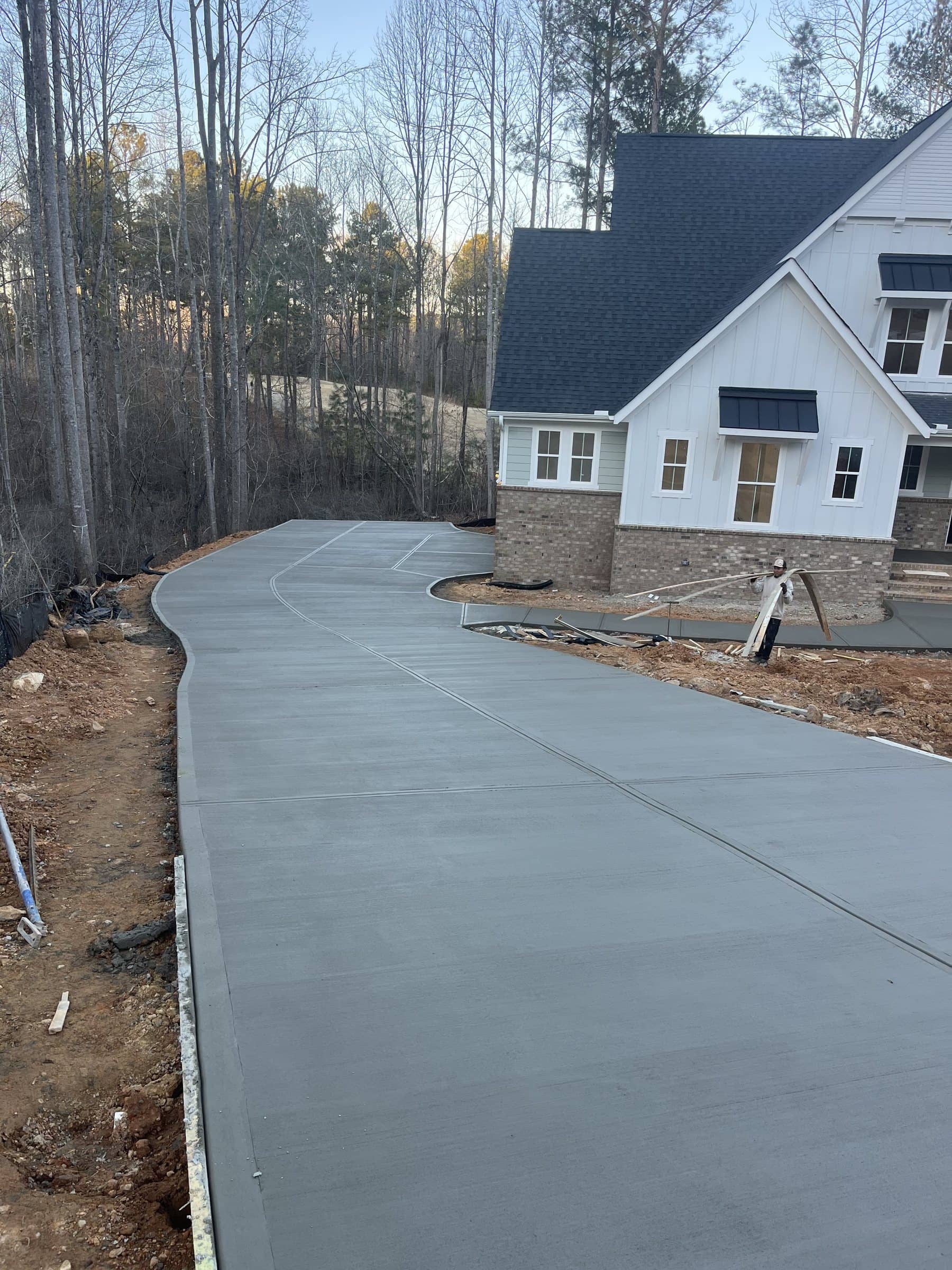 Curved concrete driveway leading to a white farmhouse near Pittsboro, NC